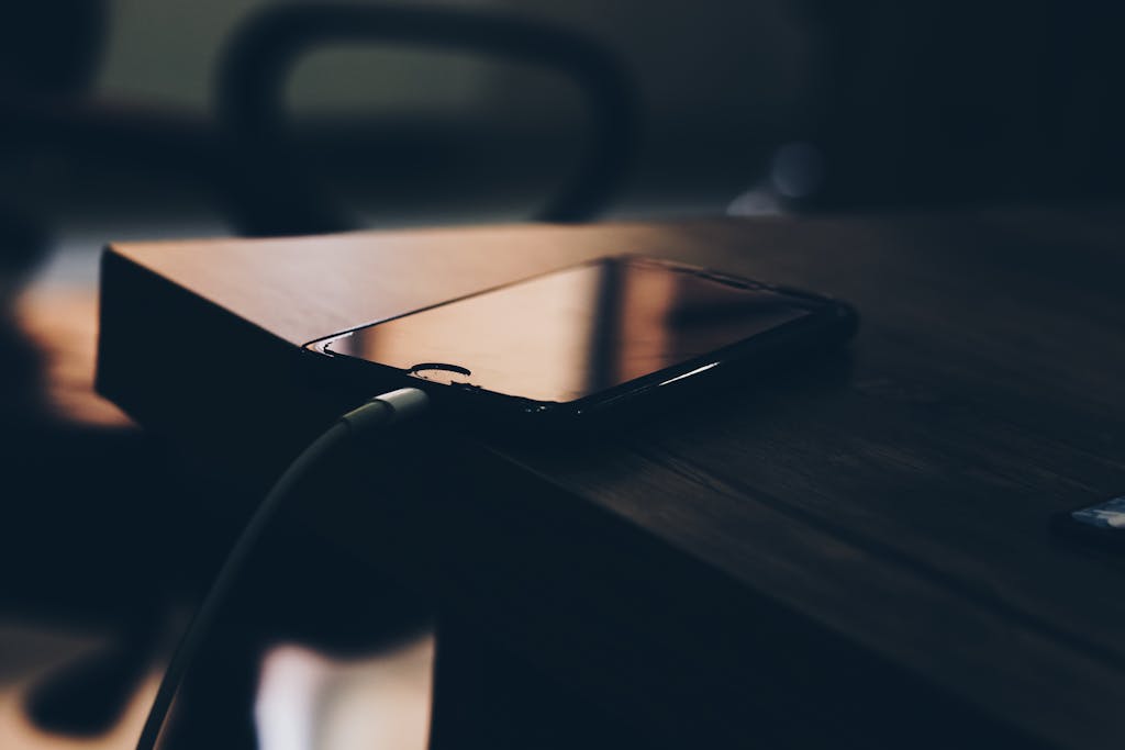 Shallow Focus Photography of Black Iphone 7 on Brown Wooden Table