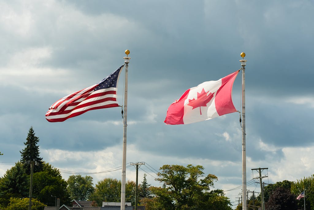 Canadian and American flags waving under a cloudy sky in Harbor Beach, MI.