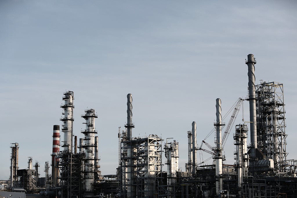 Skyline view of an industrial factory with tall chimneys against a clear sky.