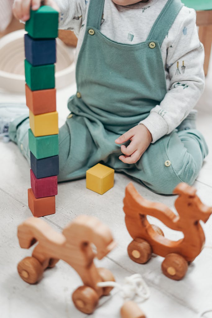 A child enjoying playtime indoors with colorful wooden blocks and toys.